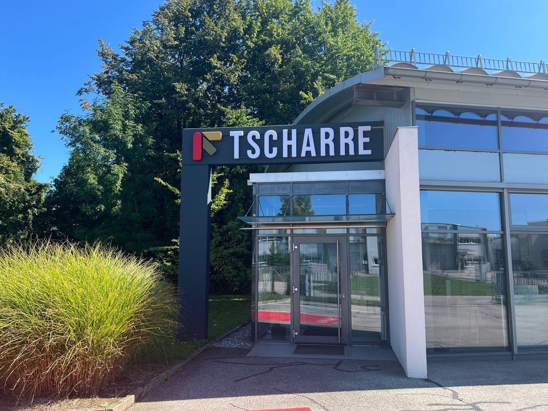 Schriftzug „Tscharre“ mit Logo über dem Eingang.